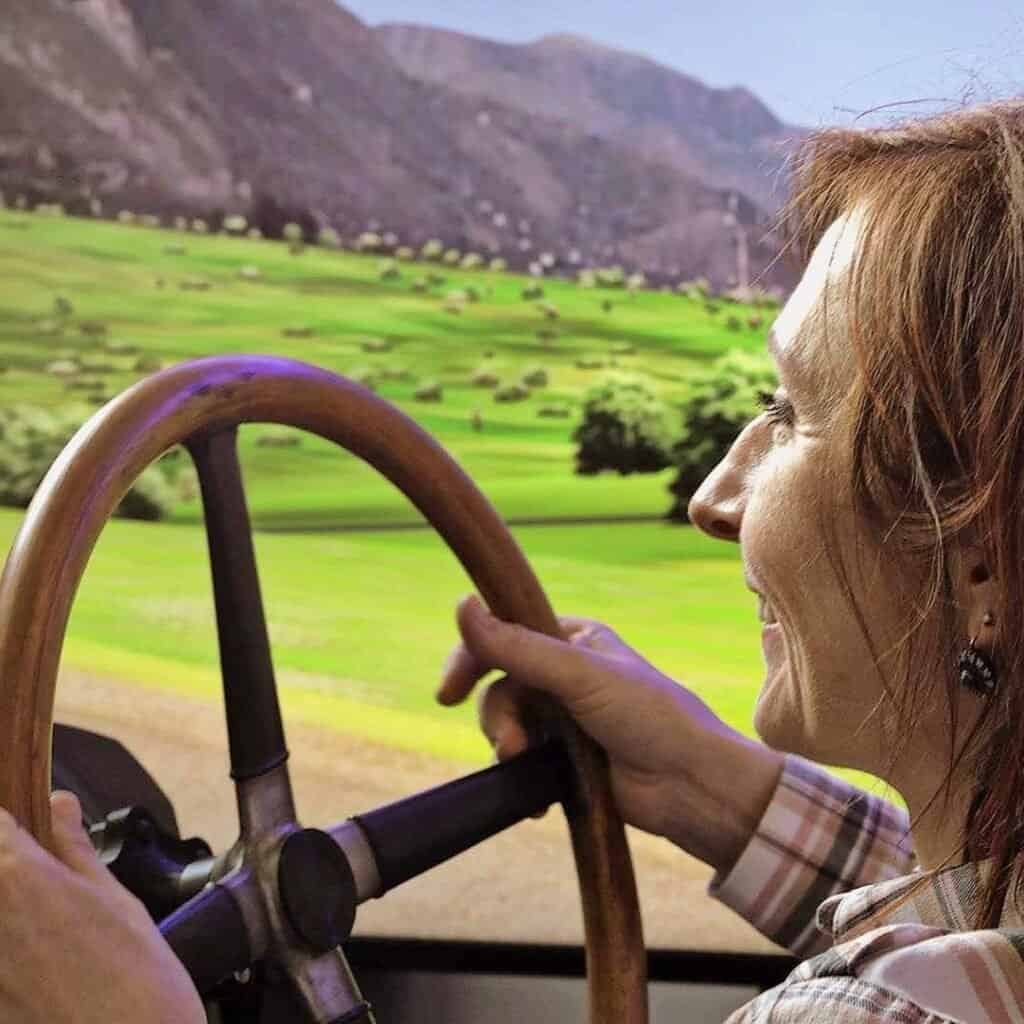 RoarFun Clients Eliska Junkova heritage happy woman with Eliska Junkova steering wheel on VR motion simulator Targa Florio Bugatti immersive experience